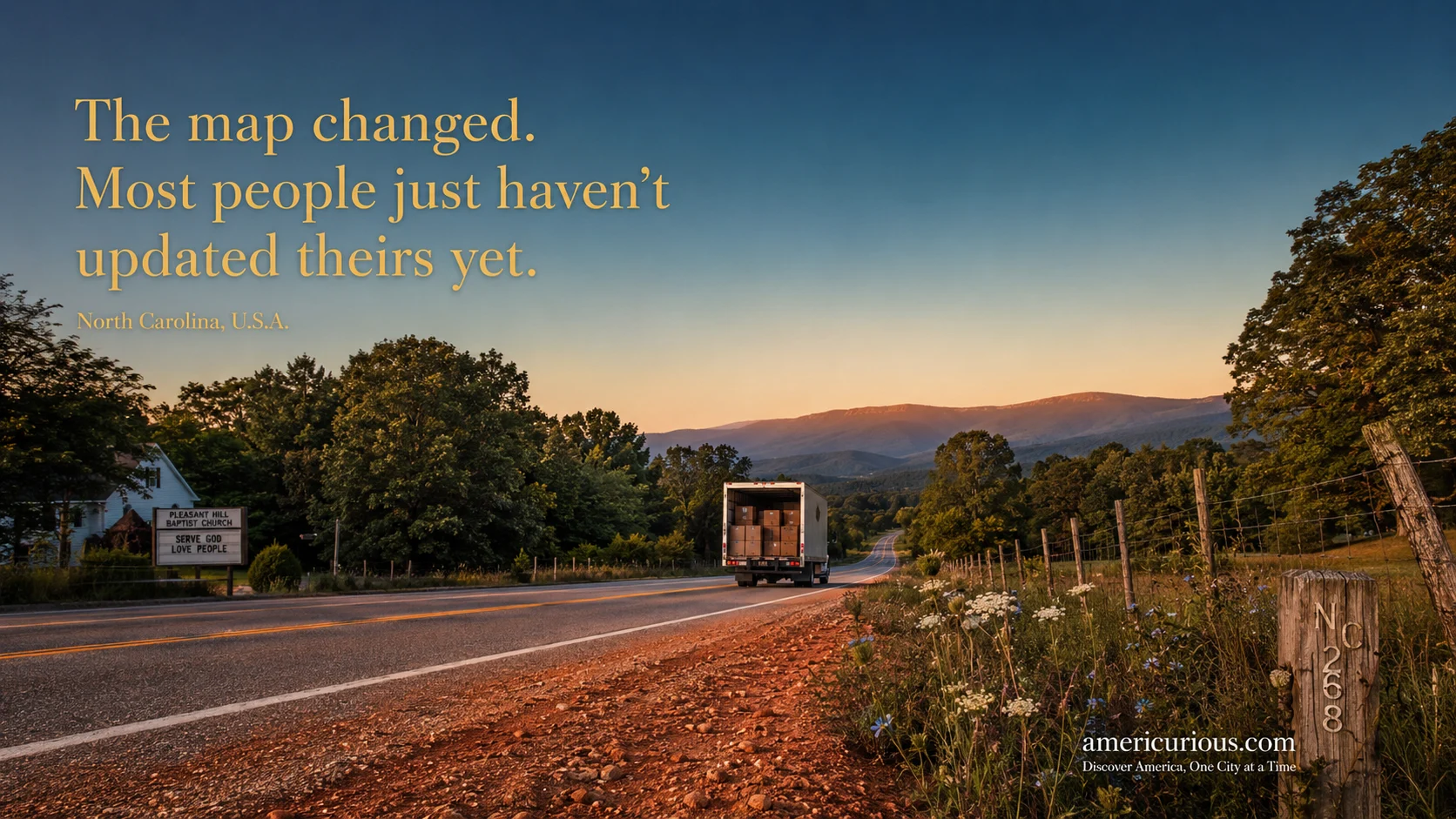 A panoramic dusk photograph of a white moving truck traveling down a two-lane North Carolina highway toward the Blue Ridge foothills, representing the 2026 American domestic migration shift toward the Carolinas and away from traditional Sun Belt metros — americurious.com migration map guide