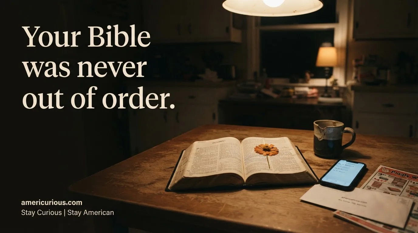 Worn open Bible with a pressed zinnia on the page beside a glowing phone and coffee mug on a kitchen table at night; headline reads "Your Bible was never out of order."