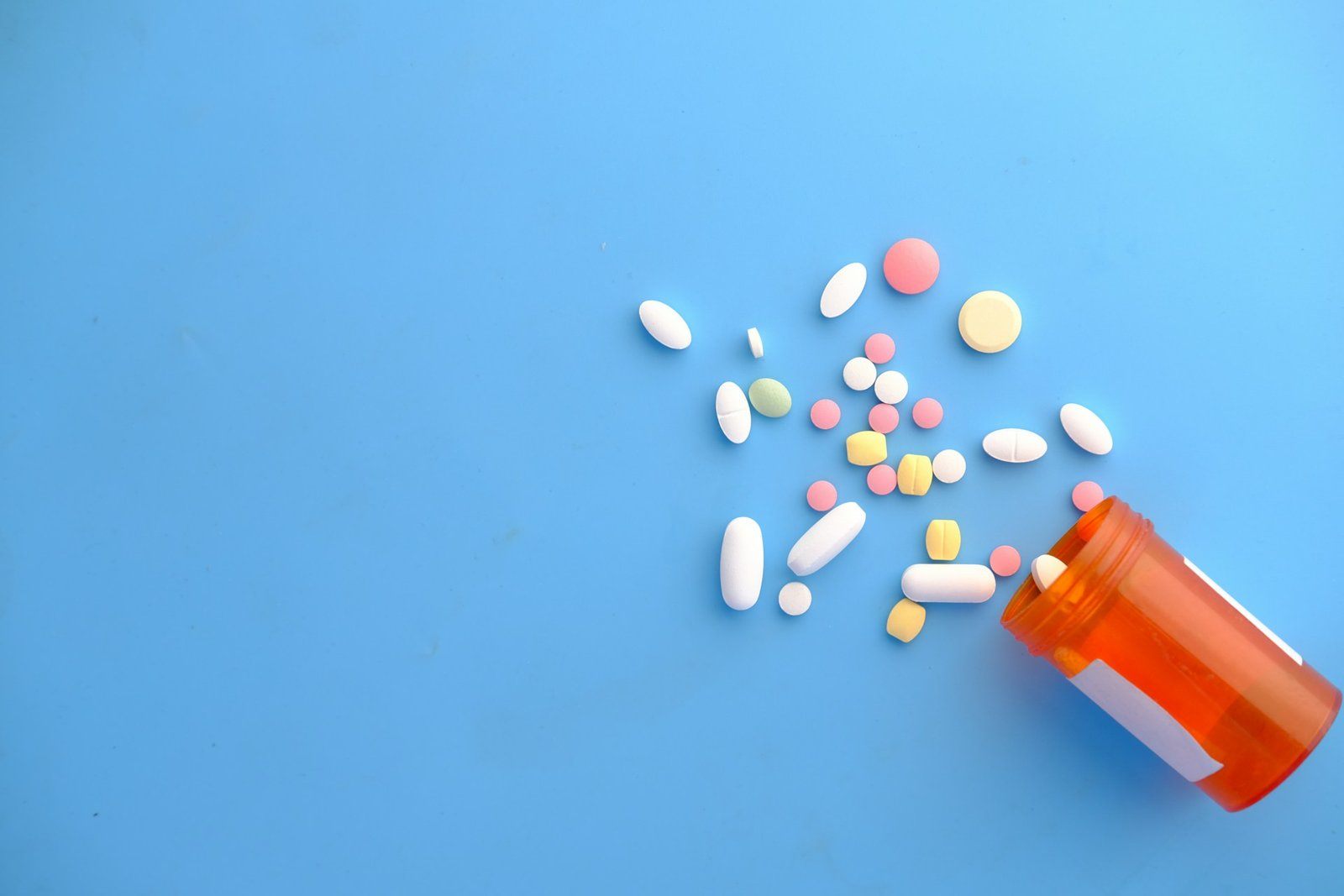 colorful-pills-spilling-from-orange-bottle