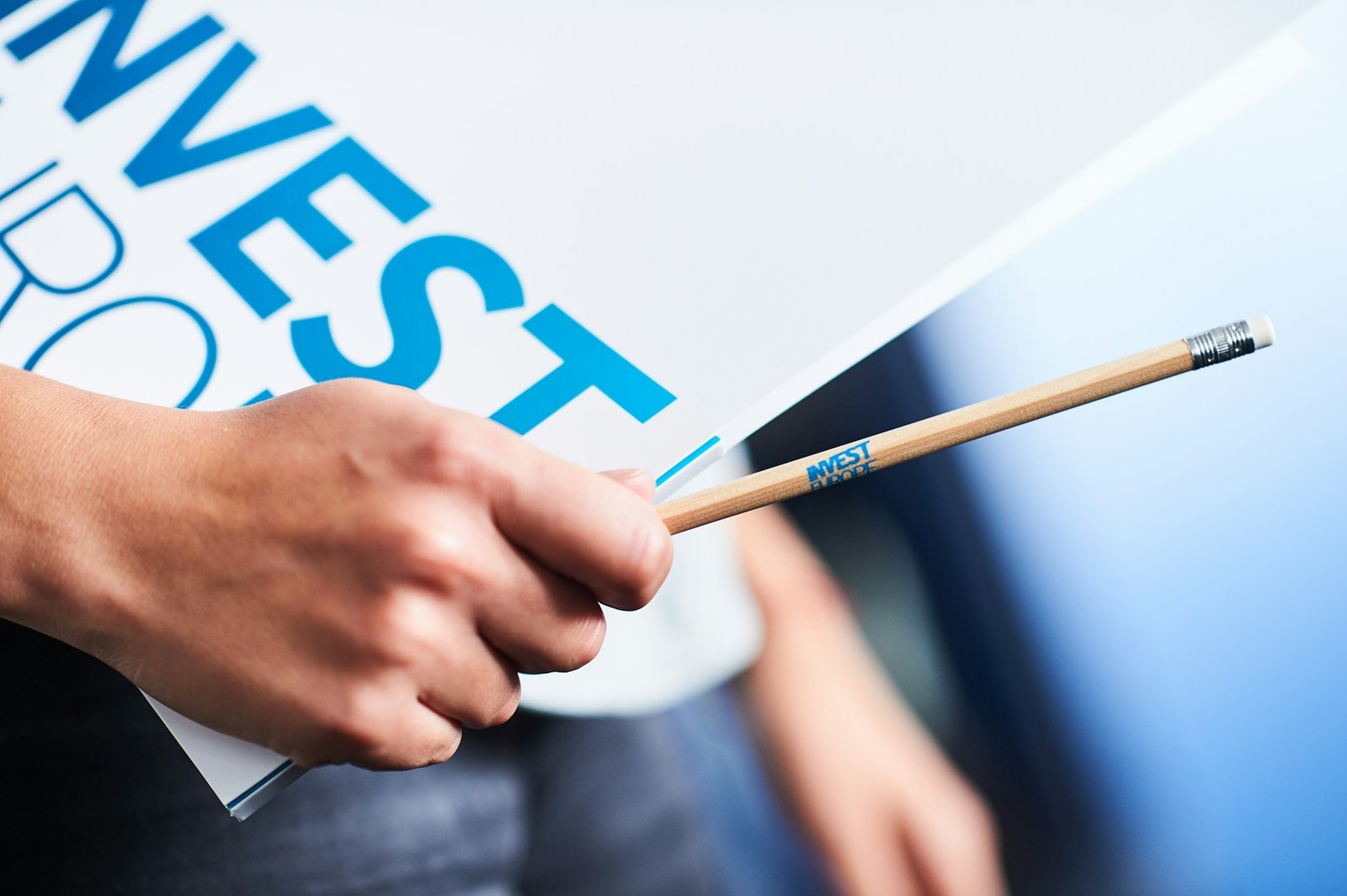hand-holding-invest-sign-and-pencil